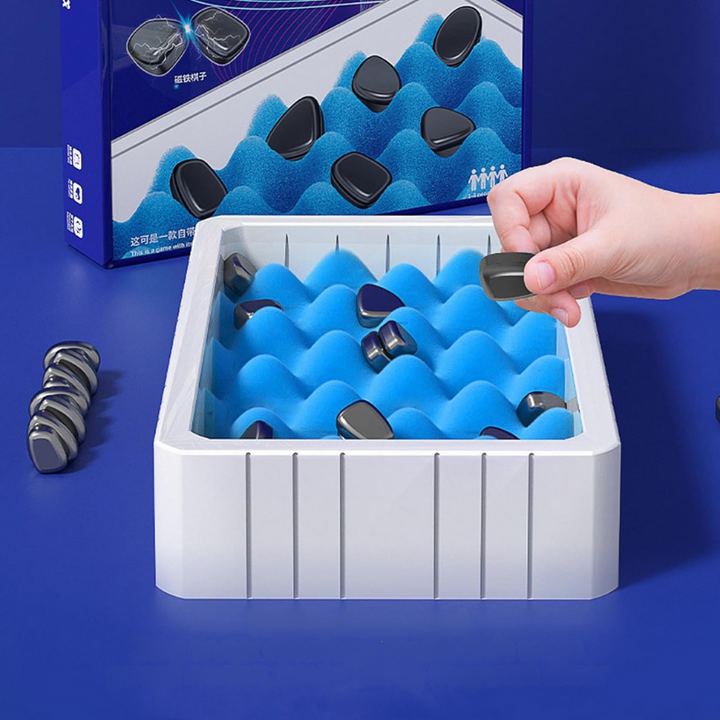 Hand greift nach schwarzem Magnetspielzeug in blauer Schaumstoffbox, Spielzeug für Stressabbau.