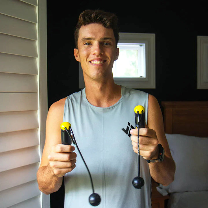 Mann mit Springseil, gelbe Griffe, Sportbekleidung, Fitness, Training, Innenraum.