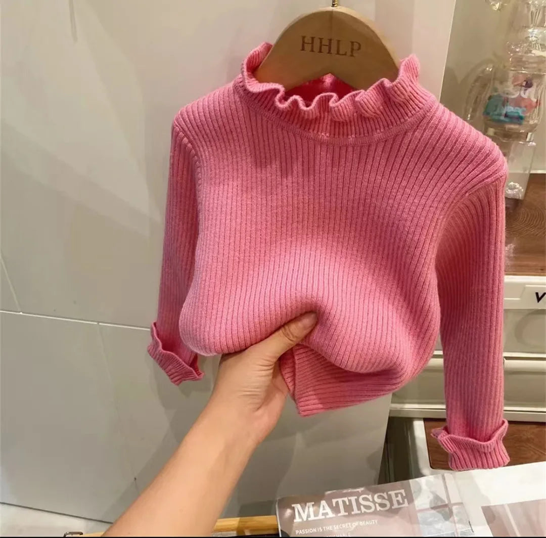 Rosa gerippter Pullover für Kinder, Rollkragen, Baumwolle, Herbstmode, auf Holzkleiderbügel.