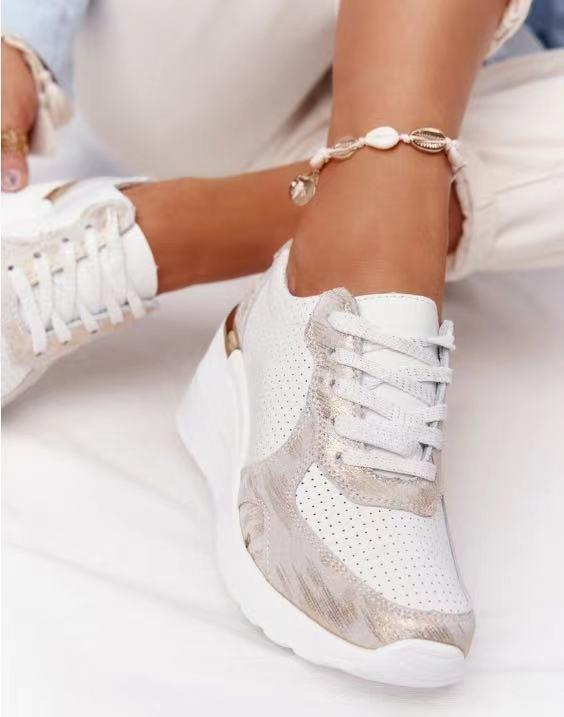 Weiße Damen-Sneaker mit Keilabsatz, perforiertem Design und goldenen Akzenten, bequem.