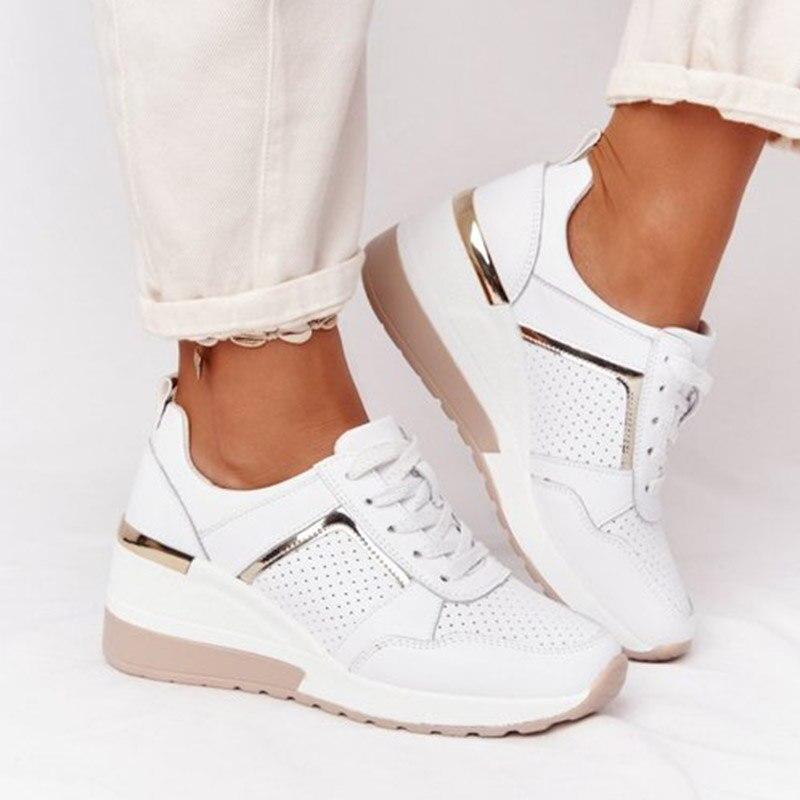 Weiße Damen-Sneaker mit Keilabsatz, perforiertem Design, goldenen Akzenten, bequem.