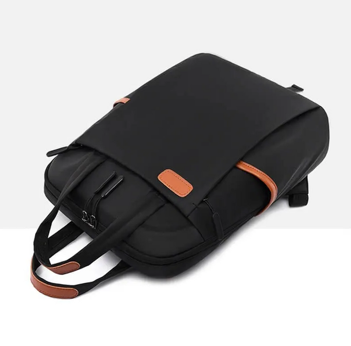 Schwarzer Laptop-Rucksack mit braunen Lederakzenten, modern und wasserabweisend.