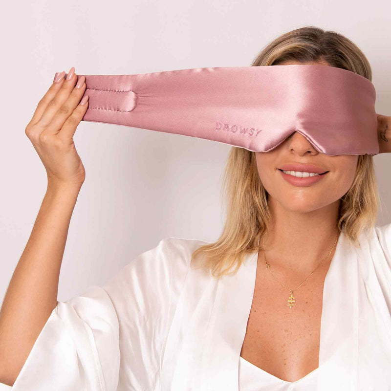 Frau trägt rosa Seiden-Schlafmaske, strapless Design, Drowsy, luxuriös, entspannend.