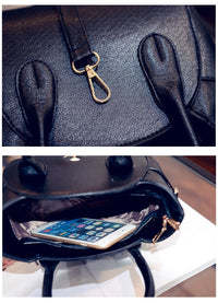 Schwarze Ledertasche mit goldener Schnalle, Innenfach mit Smartphone, modisches Accessoire.