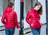 Frau in roter Daunenjacke, Kapuze, Wintermode, Outdoor-Bekleidung, stilvoll, warm.