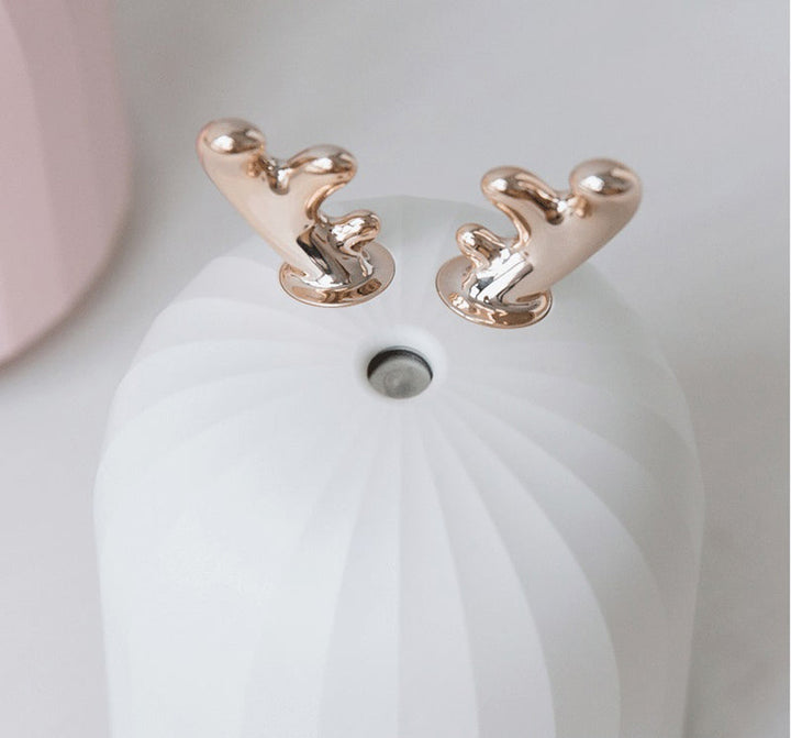 Roségoldene Ohrringe auf weißem Hintergrund, elegantes Design, Schmuckaccessoire.