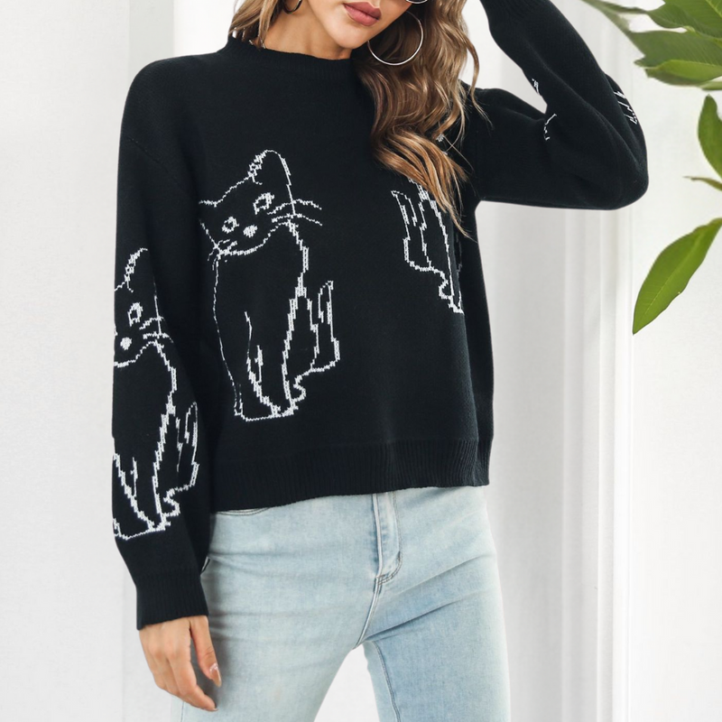 Frau trägt schwarzen Pullover mit Katzenmotiv, Damenmode, lässig, Herbst, Strick, Jeans.