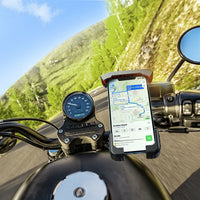 Motorradlenker mit Smartphone-Halterung, GPS-Navigation, kurvige Straße, sonniger Tag.