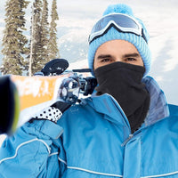 Mann mit blauer Skijacke, Skibrille und Skiern im Schnee, Winterbekleidung, Outdoor-Sport.