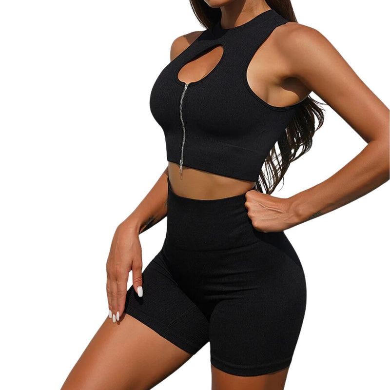 Frau in schwarzem Sport-Set, ärmelloses Top mit Reißverschluss, Shorts, Fitnessmode.