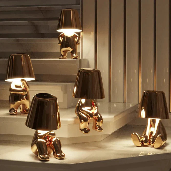 Goldene Lampen in Form von sitzenden Figuren auf Treppe, modernes Design, Innenbeleuchtung.
