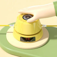 Gelbes elektronisches Spielzeug mit Hand, digitalem Display und Kabeln auf grünem Untergrund.