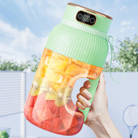 Grüner tragbarer Mixer mit digitalem Display, gefüllt mit Obststücken, ideal für Smoothies.