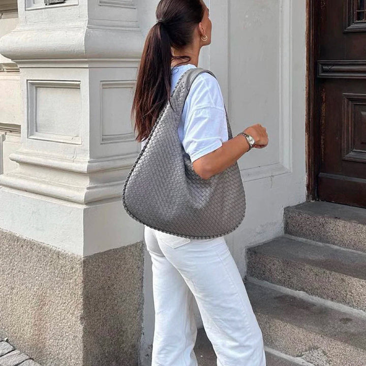 Frau mit grauer, gewebter Tote-Bag, stilvoll, geräumig, ideal für Arbeit und Alltag.