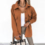 Frau in orangefarbener Jacke, weißem Top, beige Hose, hält karierte Tasche.