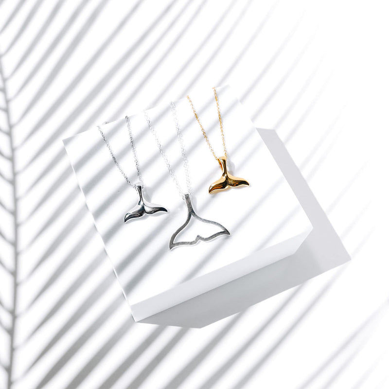 Drei Walflossen-Halsketten in Silber und Gold auf weißem Hintergrund, Schmuck, Accessoires.