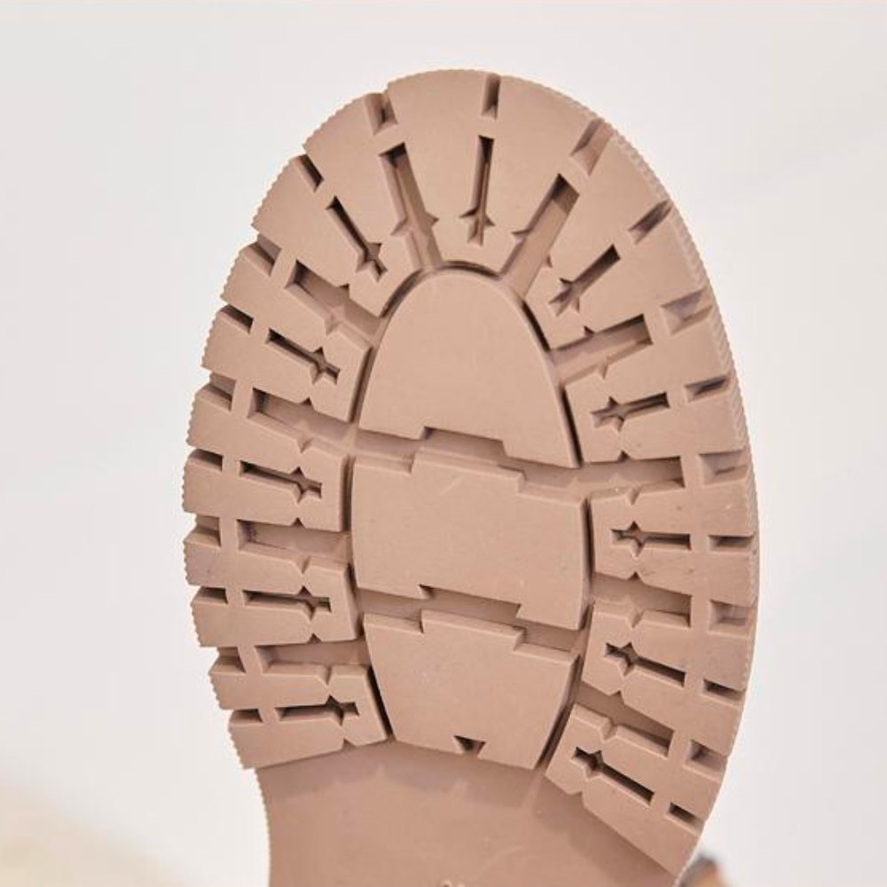 Sohle eines beigen Winterstiefels mit rutschfestem Profil, warm und bequem.