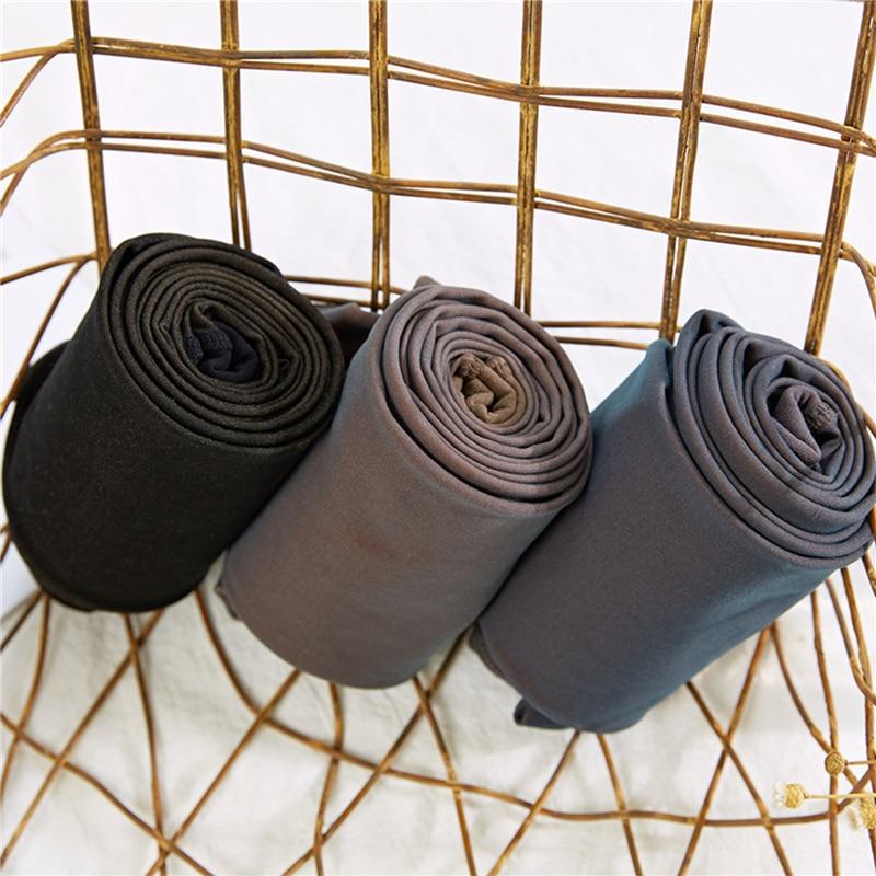 Drei Paar extra warme Leggings, schwarz, grau, blau, auf einem goldenen Drahtkorb.