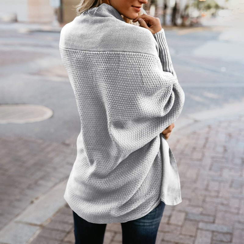 Frau in grauem Strickpullover, langärmelig, modisch, gemütlich, Straßenhintergrund.