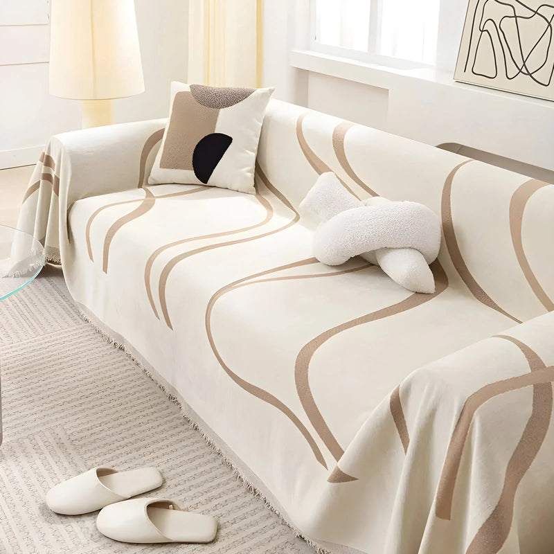 Weiße Couch mit beigem Wellenmuster, dekoriert mit Kissen und Hausschuhen, modernes Wohnzimmer.