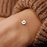 Goldenes Zodiak-Armband am Handgelenk, filigranes Design, Astrologie-Schmuck, Damenaccessoire.