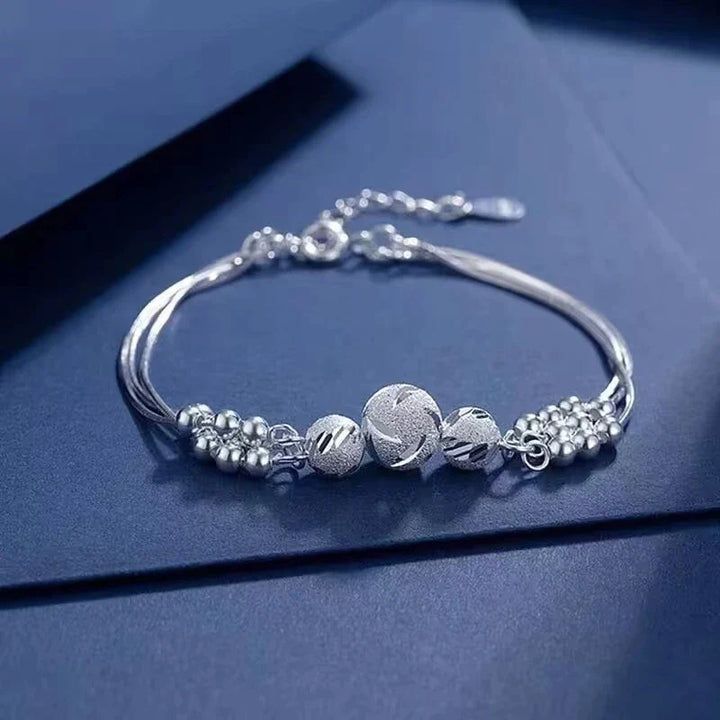 Silberarmband mit Kugelanhängern, elegantes Design, Schmuck für Damen, Geschenkidee.