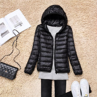Schwarze Daunenjacke mit Kapuze, Damenmode, warm, leicht, stilvoll, Herbst-Winter-Outfit.