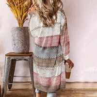 Frau in gestreiftem Strickcardigan, beige-rosa-grau, mit Kaffeebecher, Herbstmode.