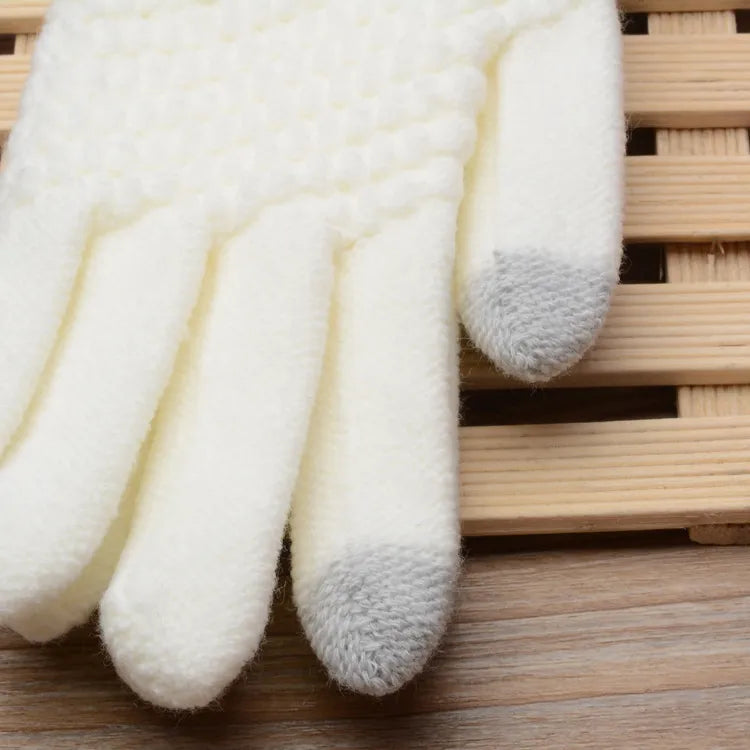 Weiße Strickhandschuhe mit grauen Fingerspitzen auf Holzuntergrund, Wintermode Accessoire.