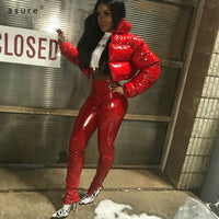 Frau in roter Lackhose und roter Daunenjacke, modisch, urbaner Stil, Nachtaufnahme.