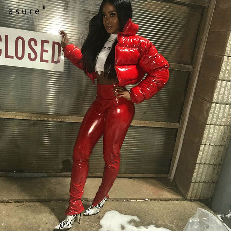 Frau in roter Lackhose und roter Daunenjacke, modisch, urbaner Stil, Nachtaufnahme.