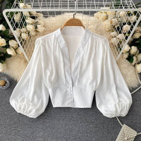 Weiße Bluse mit Puffärmeln, V-Ausschnitt, elegant, Damenmode, Baumwolle, auf Kleiderbügel.