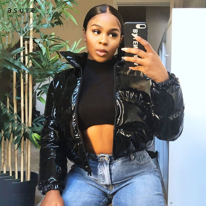 Frau in schwarzer, glänzender Daunenjacke, Jeans, Selfie, modisch, urbaner Stil.