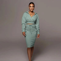 Frau in grünem Kapuzenkleid, tailliert, langärmelig, modisch, Freizeitkleidung, elegant.