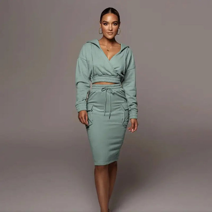 Frau in grünem Kapuzenkleid, tailliert, langärmelig, modisch, Freizeitkleidung, elegant.