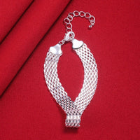 Silbernes Mesh-Armband auf rotem Stoff, verstellbar, elegantes Schmuckdesign.