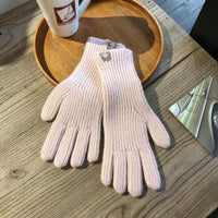 Rosa Strickhandschuhe aus Wolle auf Holztisch, Damenmode, Winteraccessoire, stilvoll und warm.