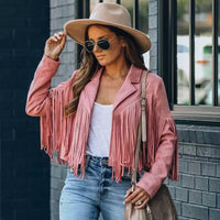 Frau mit rosa Fransenjacke, Sonnenbrille und Hut, lässiger Streetstyle-Look.