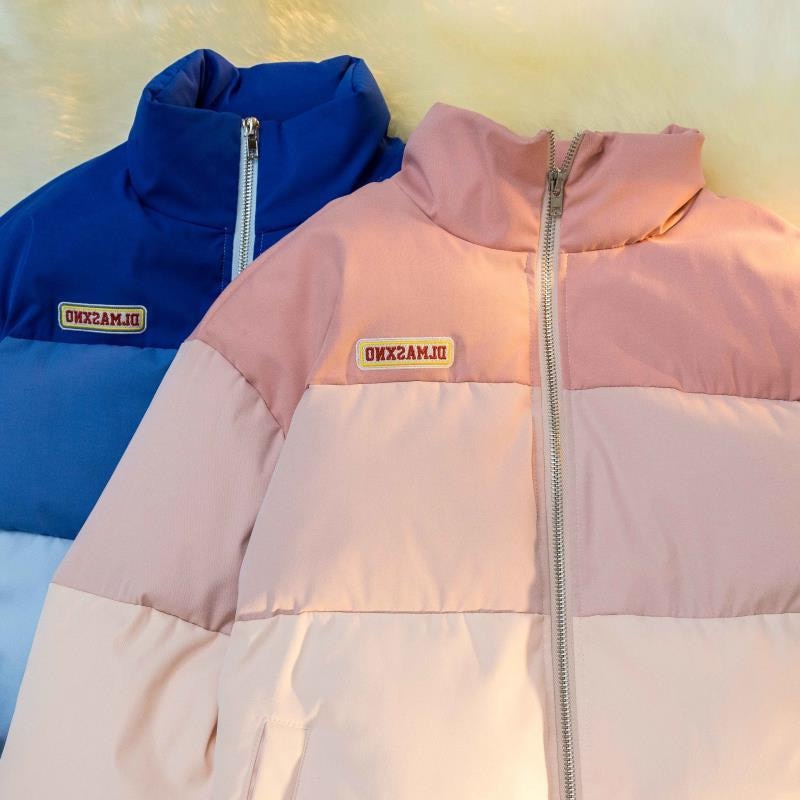 Zwei Daunenjacken, blau und rosa, mit Reißverschluss und Logo, warme Winterbekleidung.