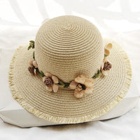 Beiger Damen-Sonnenhut aus Stroh mit Blumenverzierung, ideal für Sommermode und Strand.