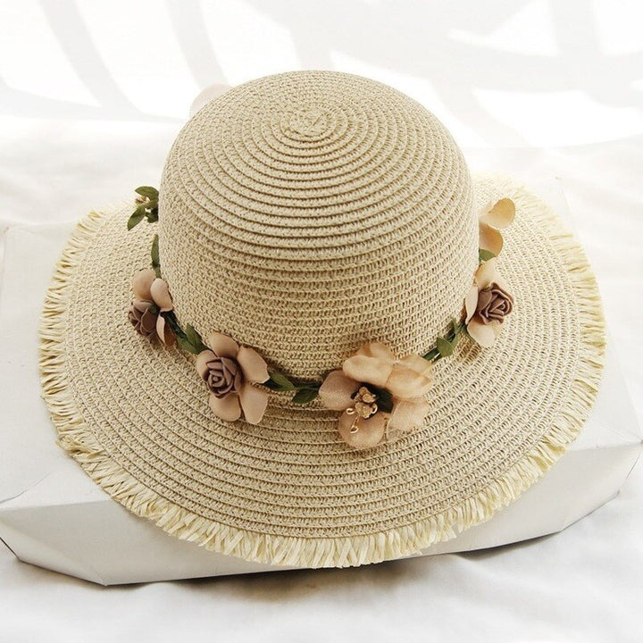 Beiger Damen-Sonnenhut aus Stroh mit Blumenverzierung, ideal für Sommermode und Strand.