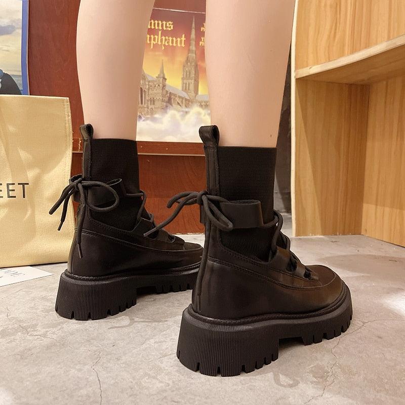 Schwarze Damenstiefel mit dicker Sohle, Schnürung, modisch, robust, aus Leder, seitlich fotografiert.