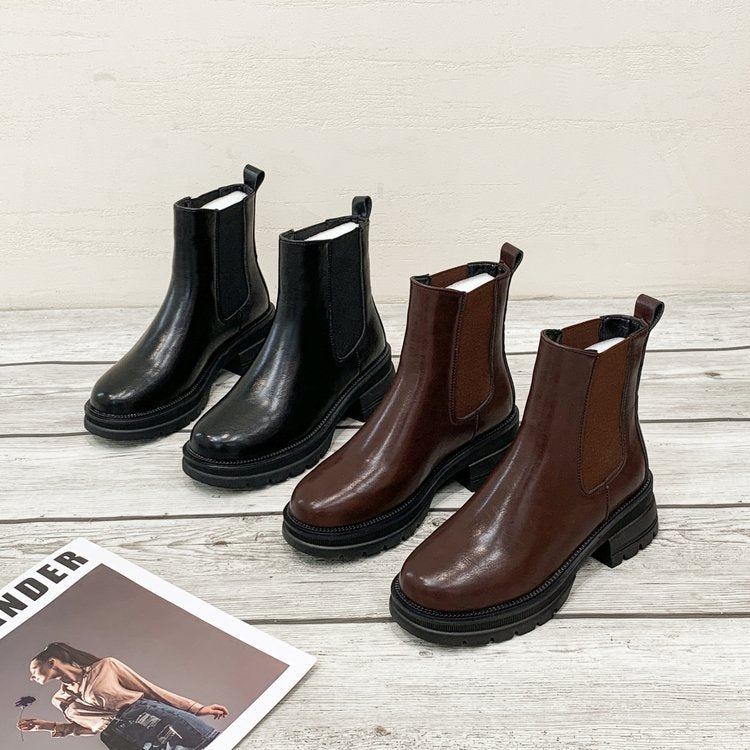 Vier Paar Chelsea-Stiefel, schwarz und braun, Leder, auf Holzboden, modisch, Herbst-Winter.