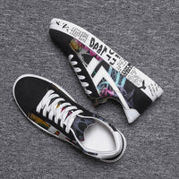 Schwarze Sneaker mit buntem Print, Textmuster, weiße Sohle, modische Freizeitschuhe.