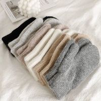 Mehrfarbige Wollsocken aus Kaschmir, weich und warm, auf weißem Hintergrund drapiert.