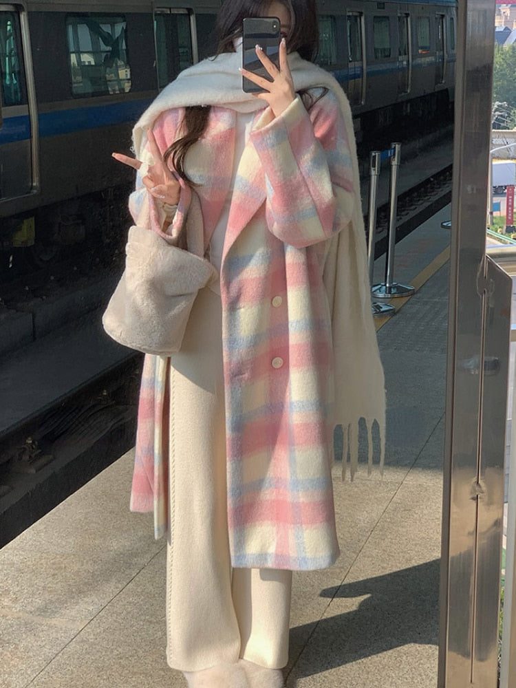 Frau in pastellfarbenem Mantel mit Schal und Tasche auf Bahnsteig, Wintermode, Streetstyle.
