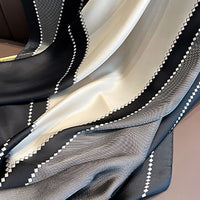 Schwarz-weißer Seidenschal mit geometrischem Muster, elegant und modisch.