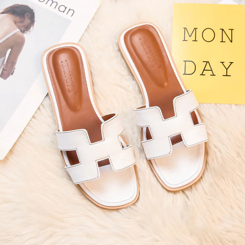 Weiße Ledersandalen auf Teppich, modisch, bequem, Damen-Sommerschuhe, flach, elegant.