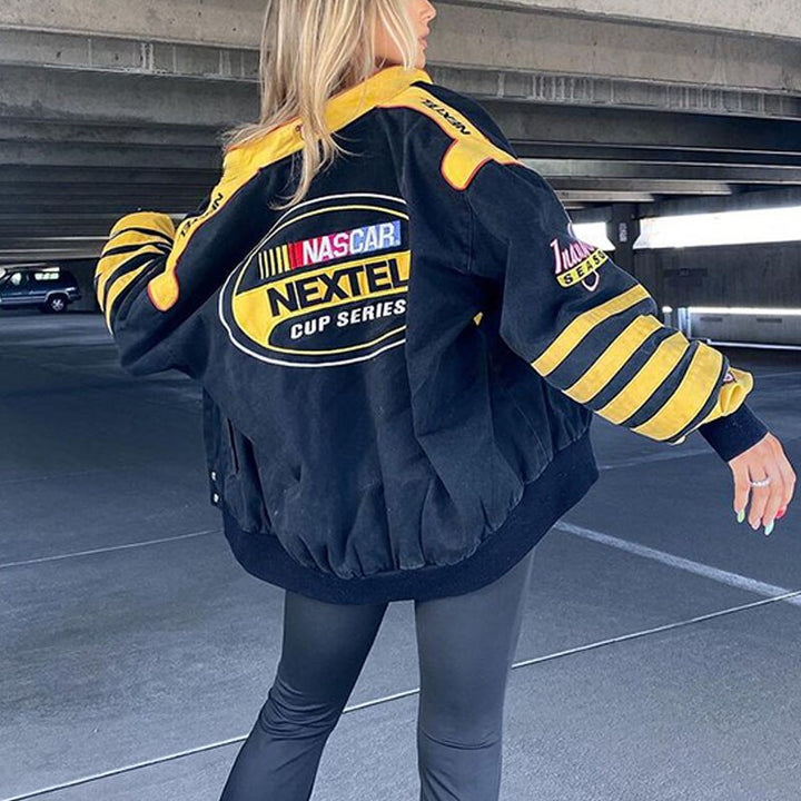 Frau in schwarzer NASCAR Nextel Jacke mit gelben Streifen, lässige Mode, Parkhaus.