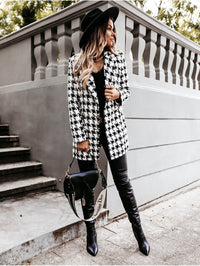 Frau in schwarz-weißem Hahnentritt-Mantel, schwarzem Hut, Lederhose, Dior-Tasche, Herbstmode.